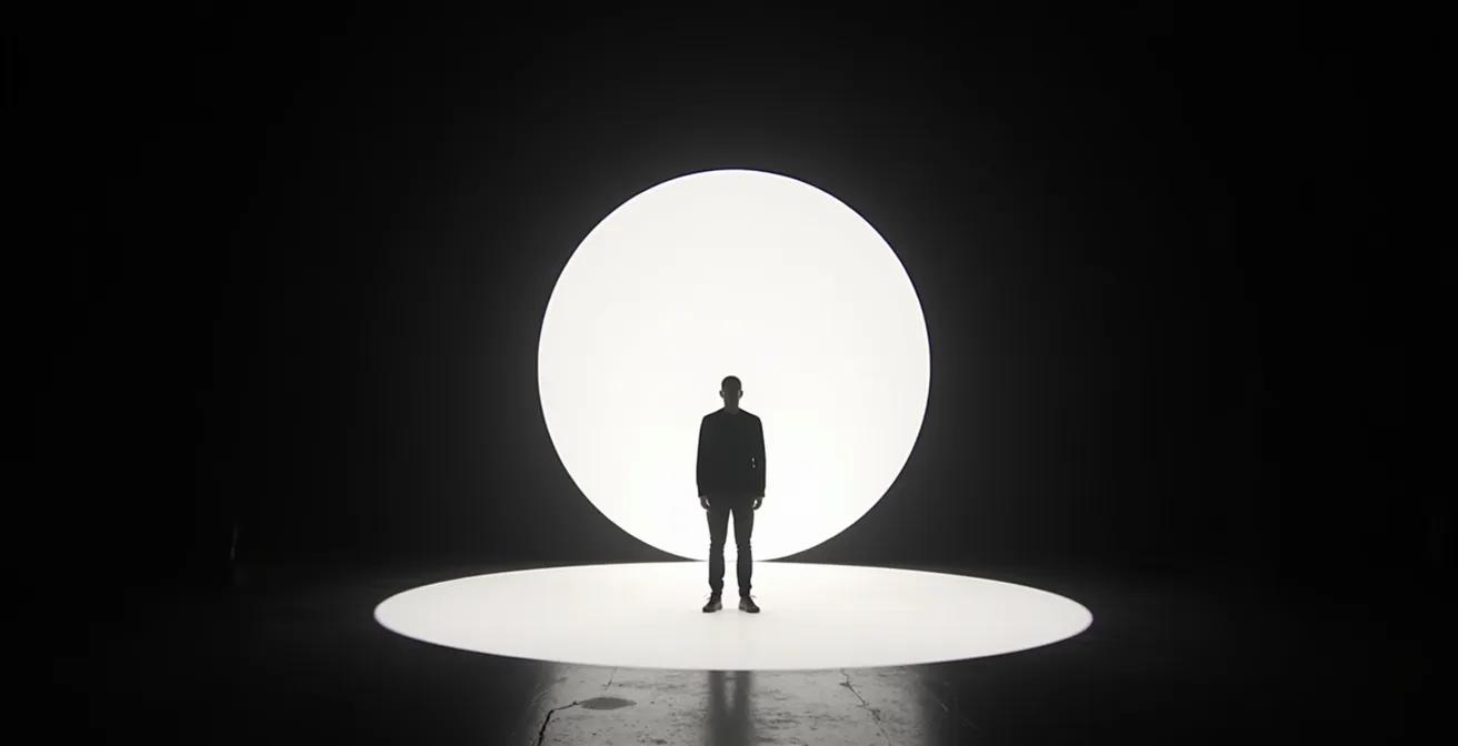 Scène épurée avec un seul musicien dans un cercle de lumière blanche sur fond noir total